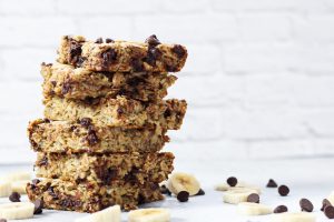 Stack of banana oatmeal surrounded by bananas and chocolate chips