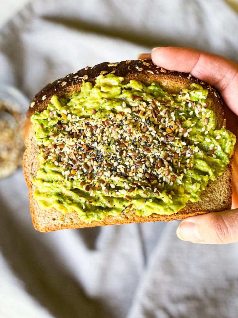 Everything but the bagel seasoning on top of a slice of toast with avocado spread. 