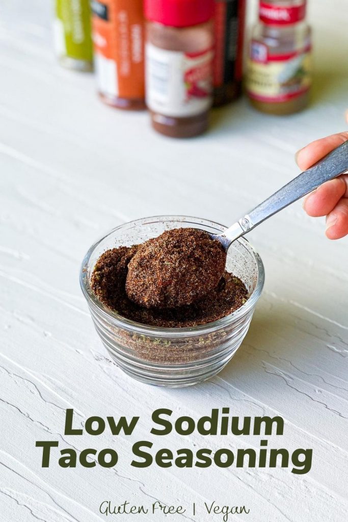 Seasonings in the background with low sodium taco seasoning in a dish with a spoon. 